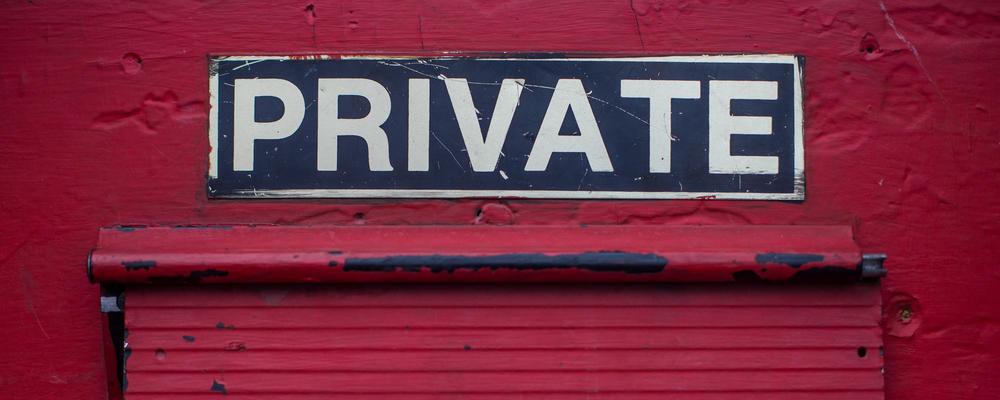 Close up of door with mail slot and sign reading "PRIVATE"