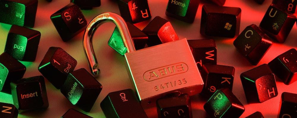 Photo illustration of an unlocked padlock and a pile of computer keyboard keys