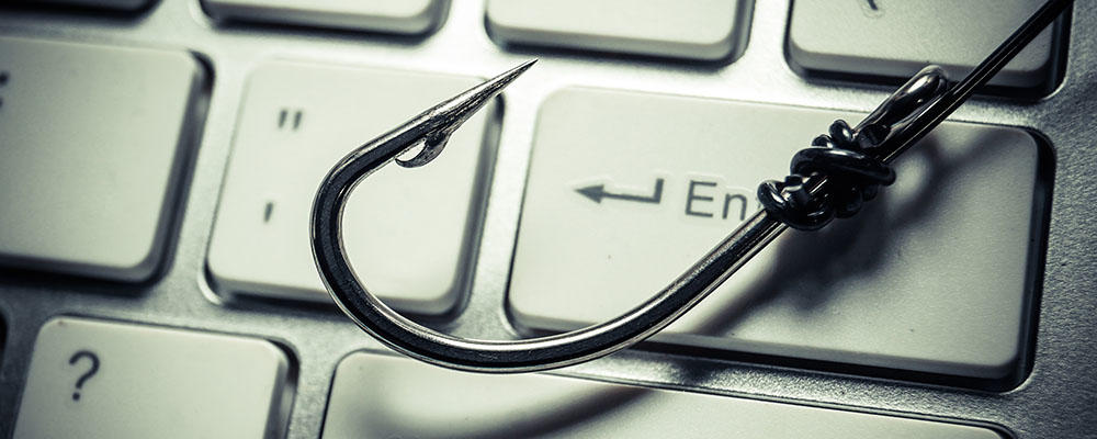 Photo illustration showing a fishhook on a computer keyboard