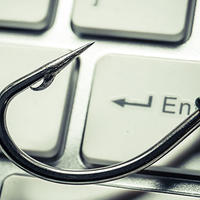 Photo illustration showing a fishing hook on a computer keyboard