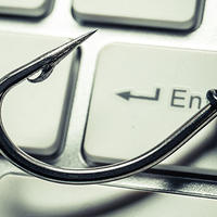 Photo illustration showing a fishhook on a computer keyboard
